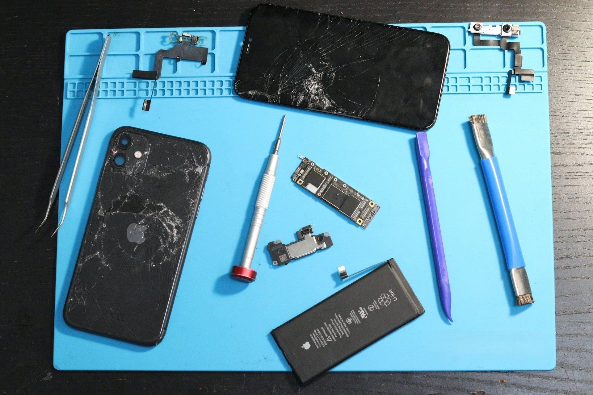 A cracked iPhone placed beside professional repair tools, ready for screen replacement at Imfixed in Bury.