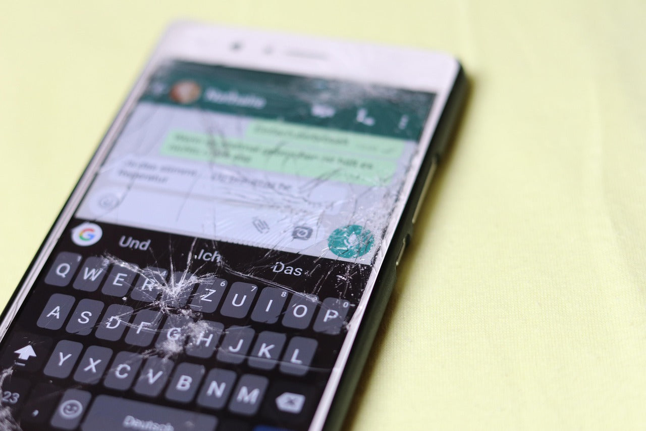 Close-up of a cracked phone screen, raising the question—can you fix your own phone screen?