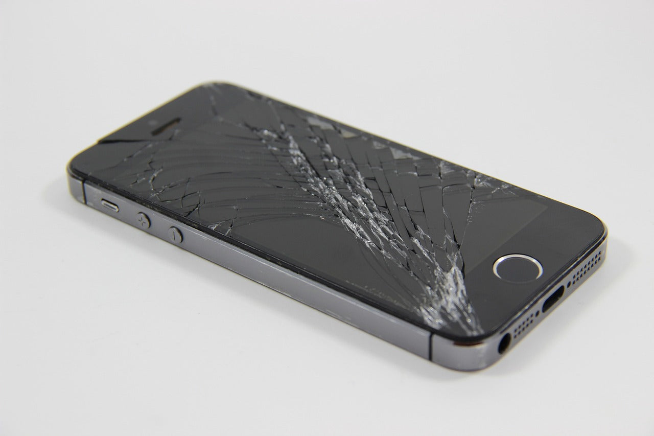 Close-up of an iPhone 5 with a cracked screen, ready for professional repair at Imfixed