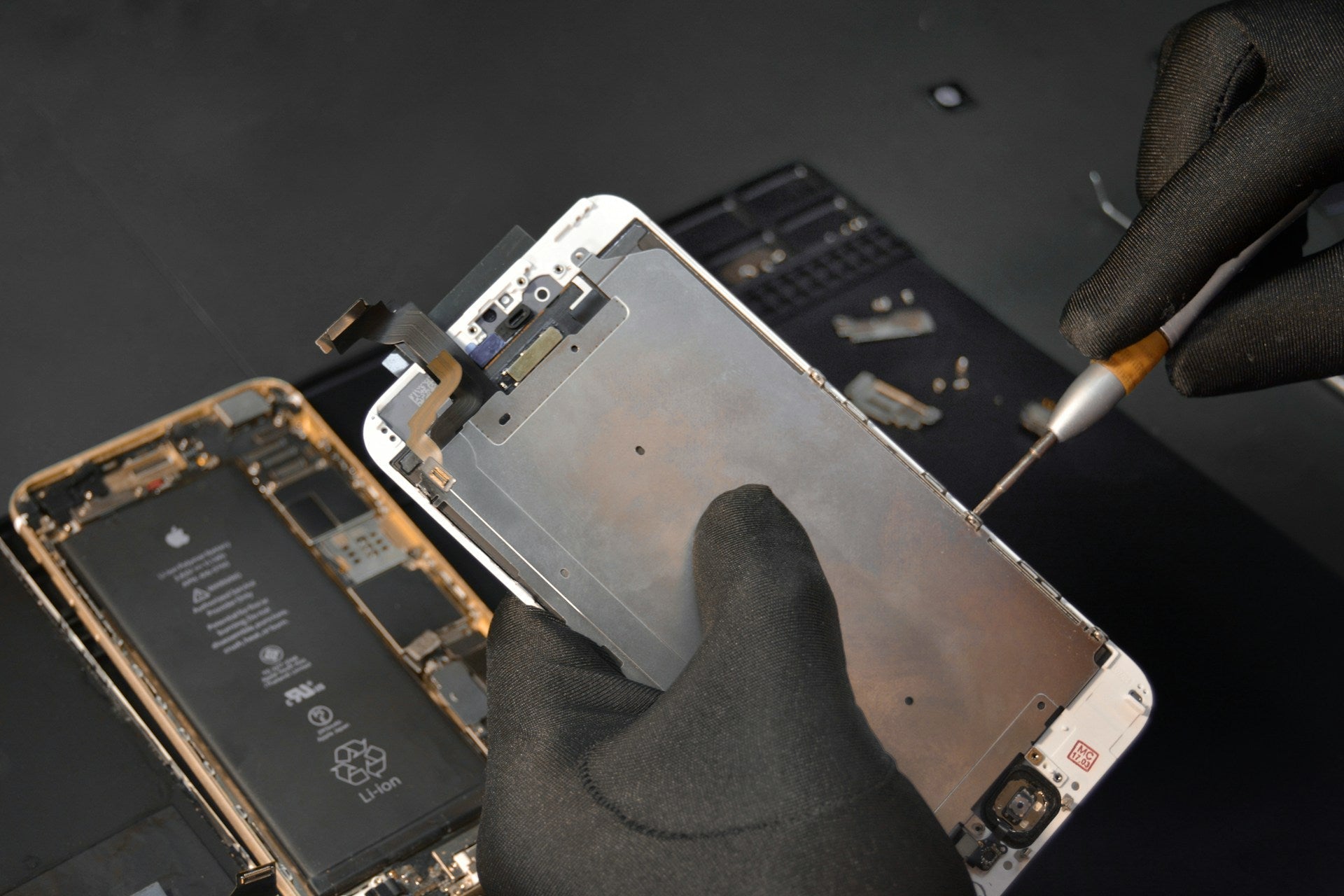 Expert technician carefully repairing or replacing an iPhone 6 Plus screen using professional tools