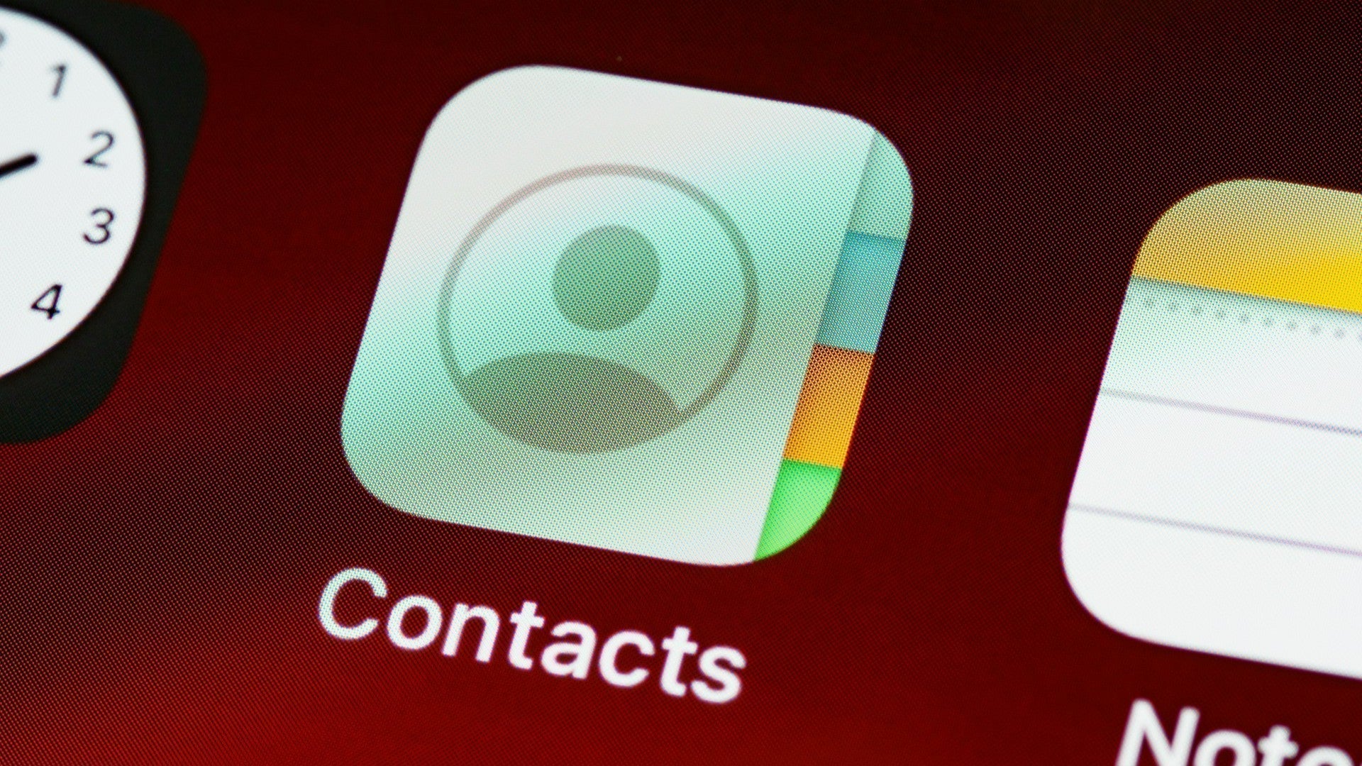 iPhone displaying the Contacts app on screen, used for managing contacts