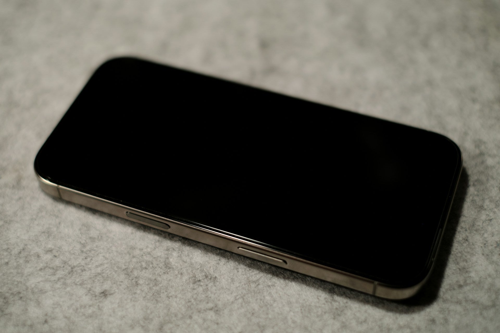 iPhone lying face-up on a table with the screen turned off, ready for screen repair at Imfixed Bolton.