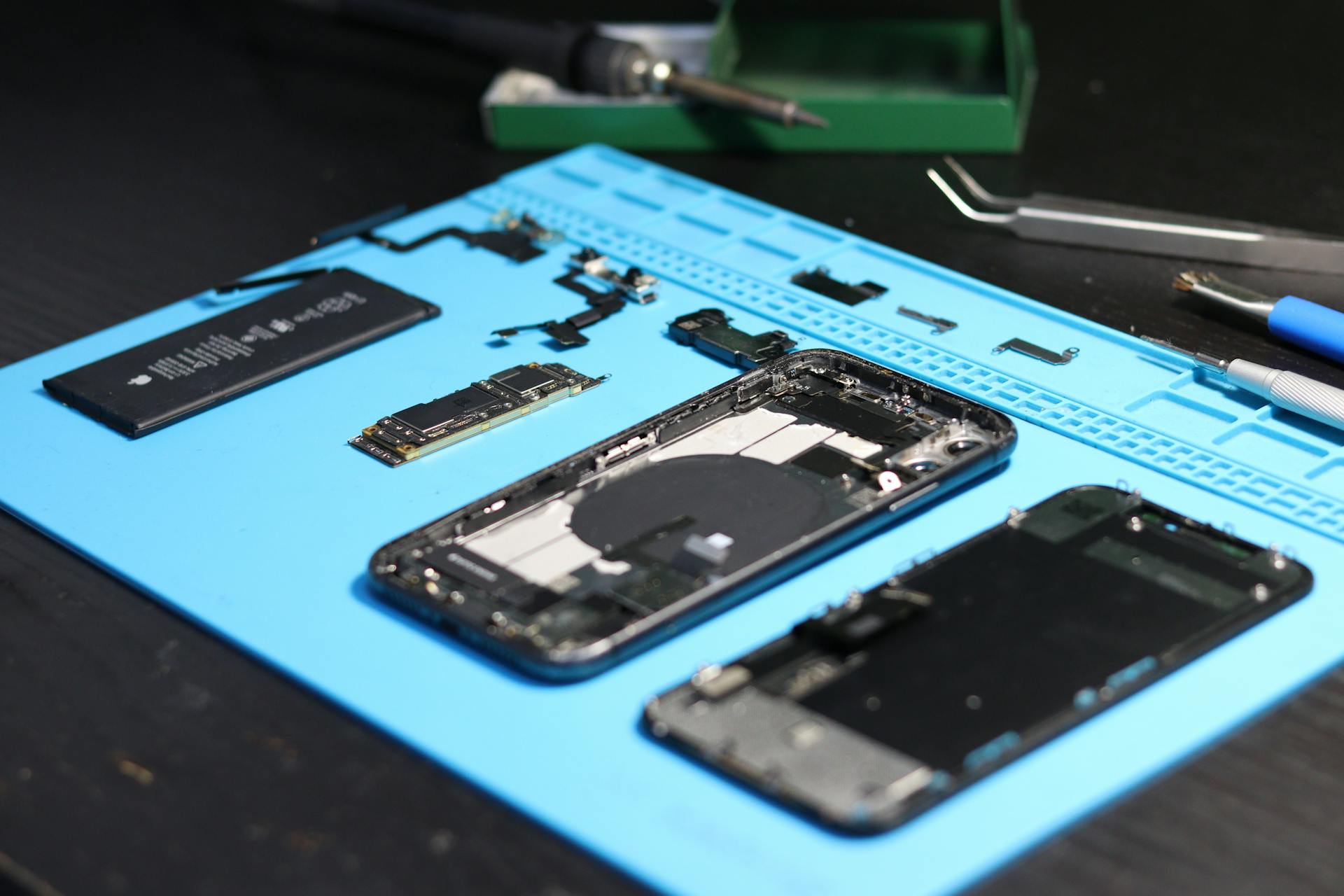 Opened mobile phone with internal parts exposed during professional repair at Imfixed
