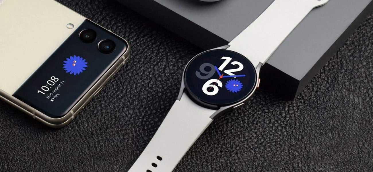 Samsung Galaxy Watch 4 displayed beside the Galaxy Z Flip4 on a sleek surface, showcasing Samsung’s latest wearable and smartphone innovations.