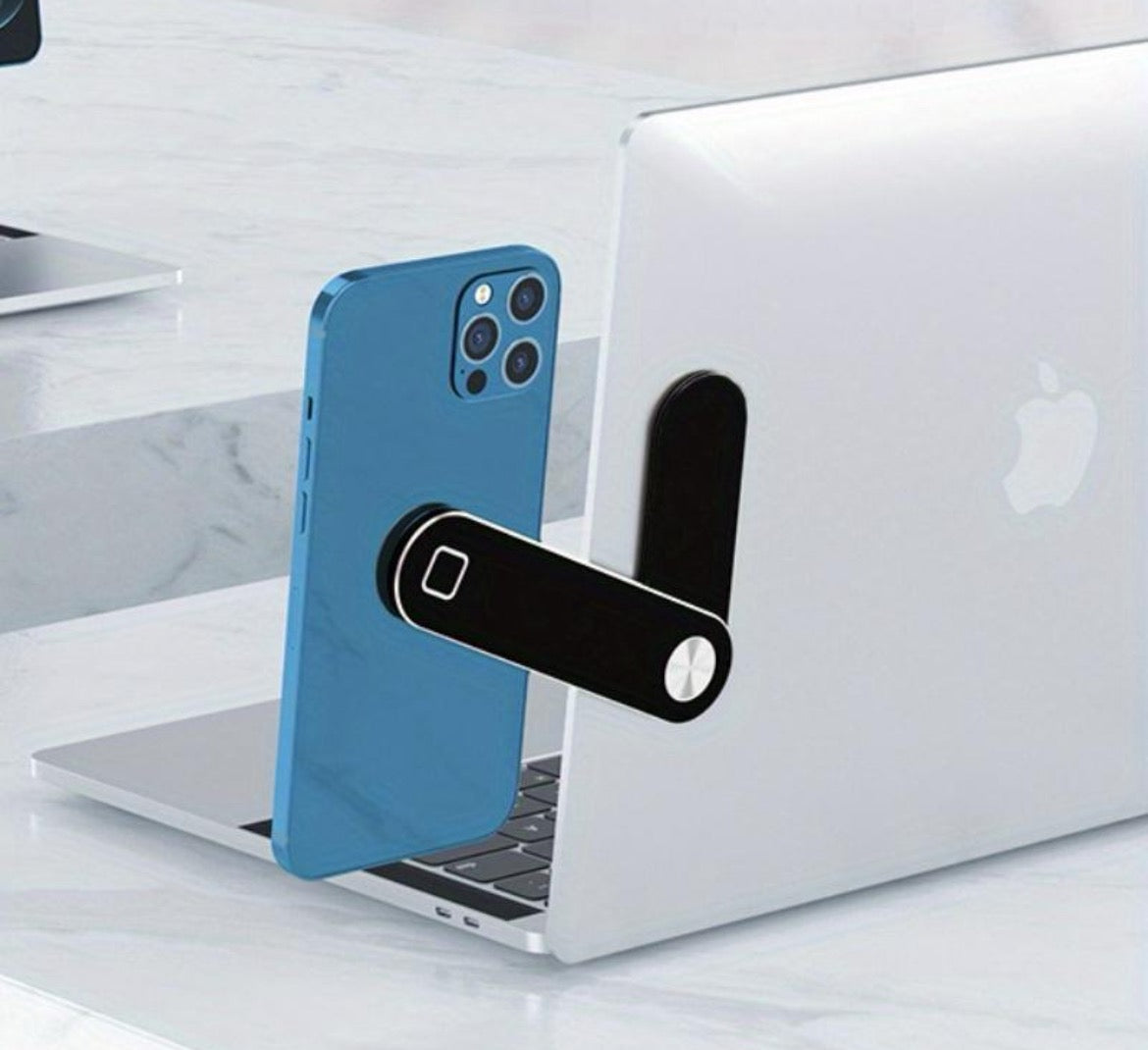 A magnetic laptop phone holder attached to the side of a laptop, holding a smartphone in place.