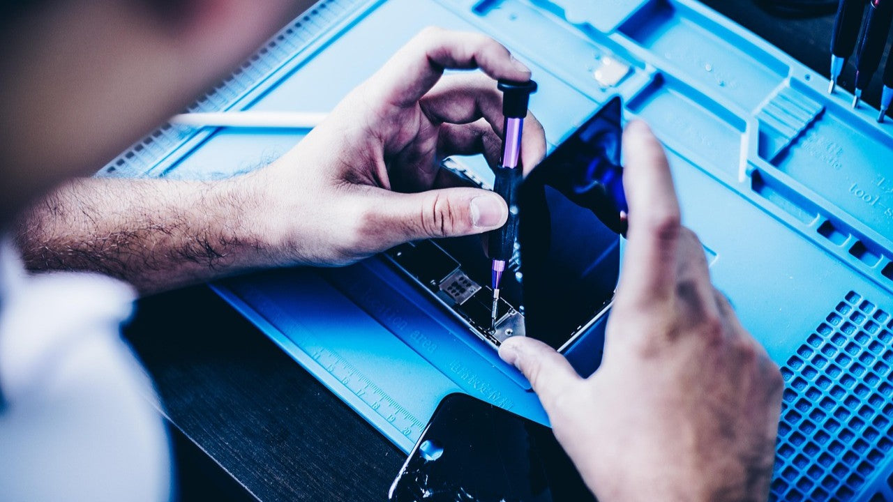 Expert technician carefully replacing an iPhone X screen on a clean workbench, highlighting proper screen fitting techniques for iPhone X, XR, XS, and XS Max.