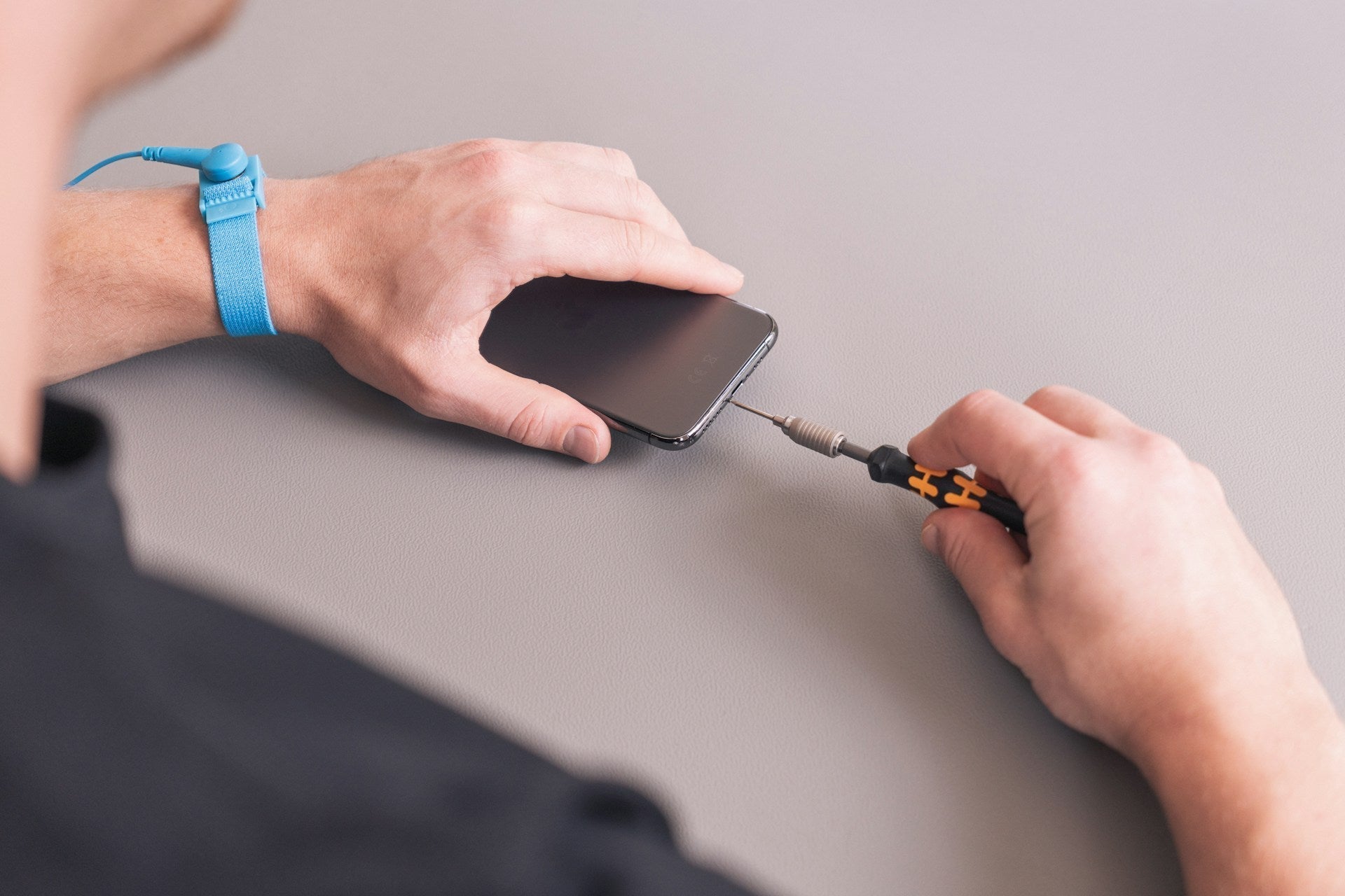 Phone repair expert fixing an iPhone with precision tools at a local repair shop in Wigan Imfixed