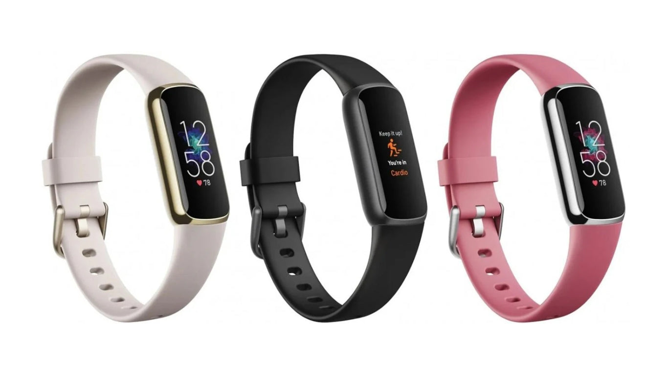 Three smart fitness trackers, including models like the Fitbit Luxe, displayed side by side on a surface for comparison.
